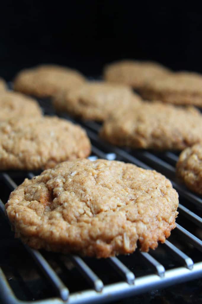 These Little Debbie's Oatmeal Cream Pies copycat are melt-in-your-mouth addicting. The cookies are bursting with buttery, chewy, brown sugar, molasses oatmeal which sand which a luscious creamy vanilla center. After one bite, you will never want to buy Little Debbies' Oatmeal Cream Pies ever again! side view of homemade oatmeal cream pies cooling on a cooling rack