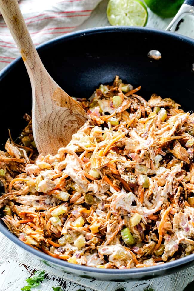 Showing how to make Smothered Buffalo Chicken Baked Burritos mixing filling in a pan.