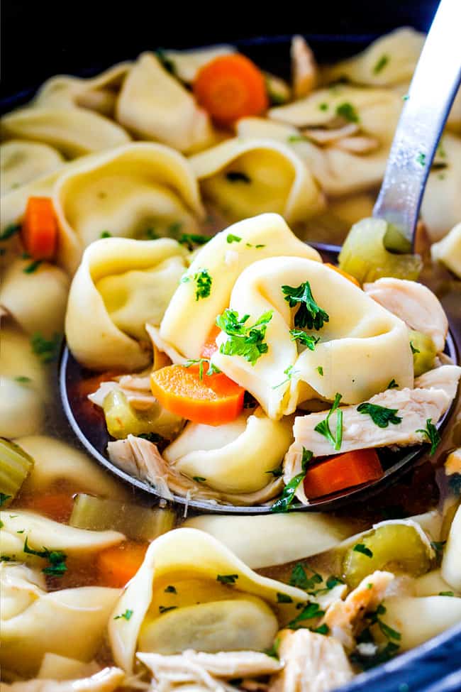 cutting celery, onions, carrots on cutting board for Slow Cooker Chicken Tortellini Soup