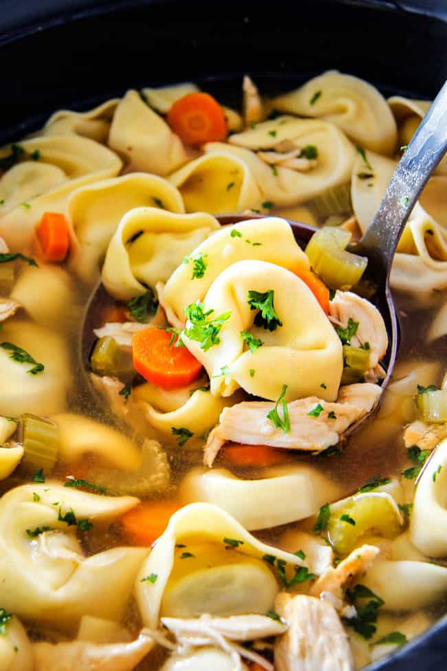 This is the BEST Slow Cooker Chicken Tortellini Soup you will ever try! It's super easy, seasoned to perfection and a comforting, satisfying dinner any night of the week! showing how to make Chicken tortellini soup by placing chicken in crockpot
