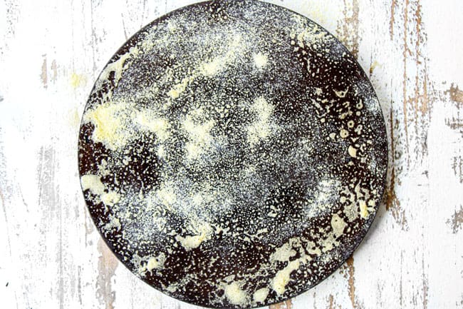 Showing how to make Homemade Pizza Dough by adding flower before rolling dough.