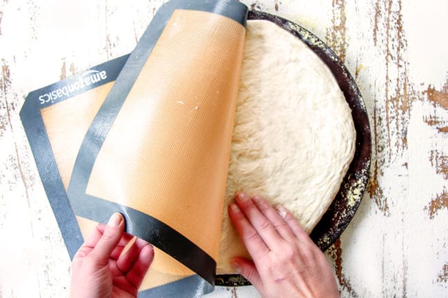 Showing how to make Homemade Pizza Dough by rolling dough onto a pizza stone