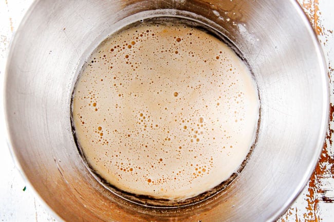 Showing how to make Homemade Pizza Dough by activating yeast in a mixing bowl.