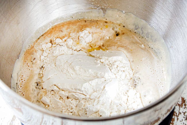 Showing how to make Homemade Pizza Dough by activating yeast in a mixing bowl also adding flour.