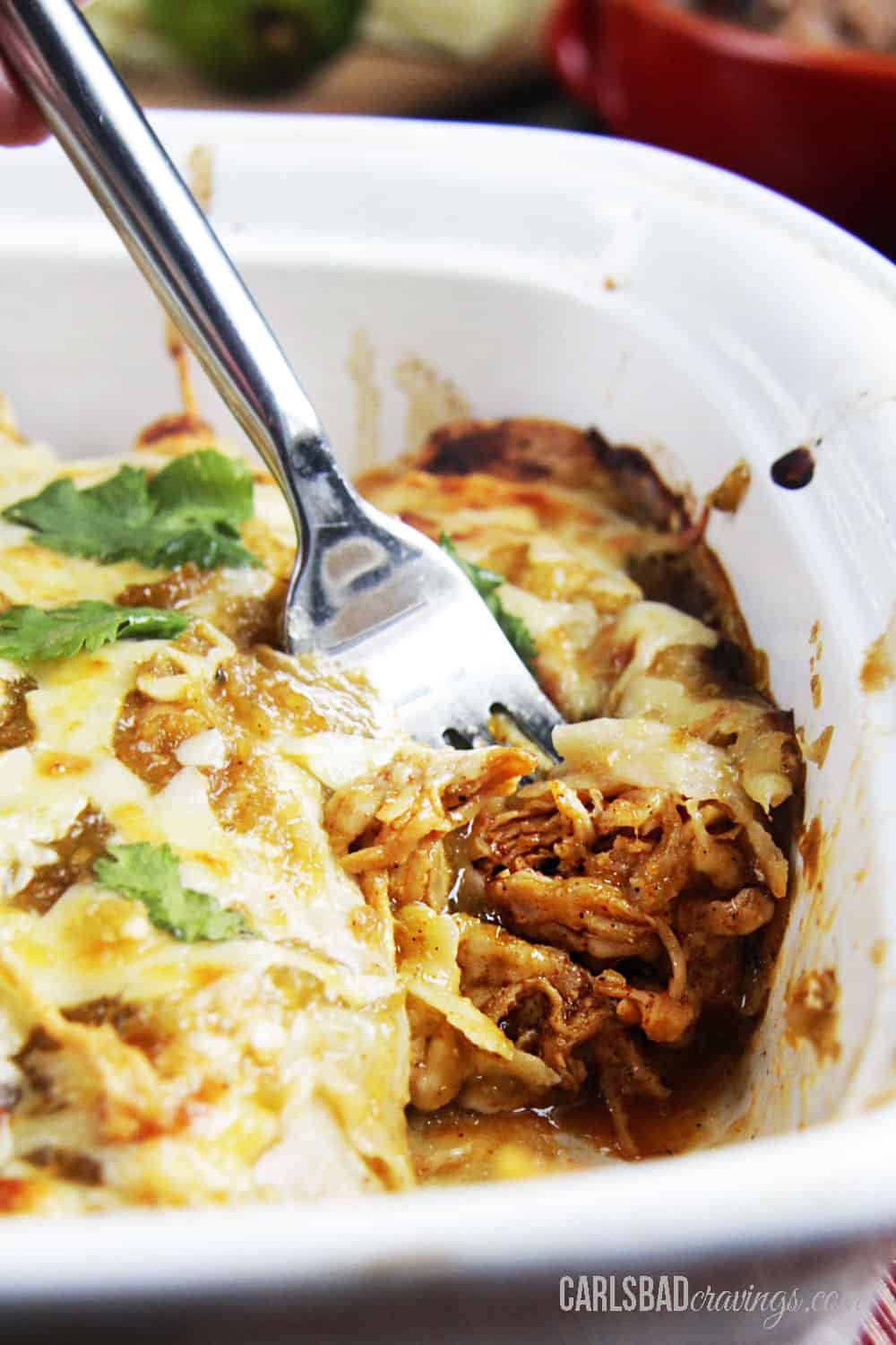 up close of taking a bite of salsa verde chicken enchiladas