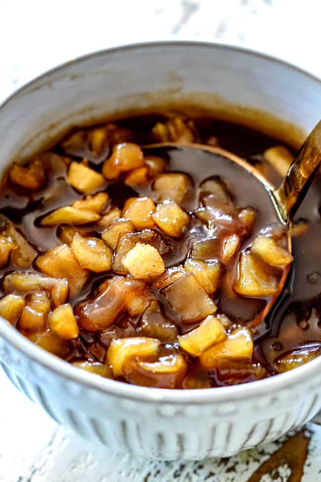chunky apple syrup in a white bowl with a ladle