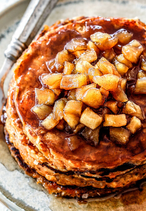 up close view of chunky cinnamon apple syrup on top of a stack of sweet potato pancakes