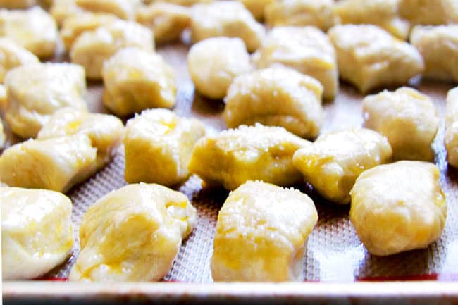 showing how to make Pretzel Bites by brushing them with butter and sprinkling with salt before baking