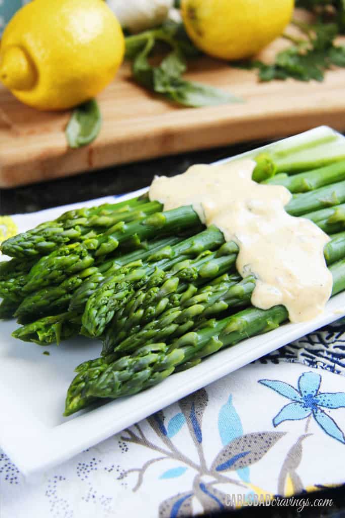 showing how to serve Healthy Hollandaise Sauce by spooning over asparagus