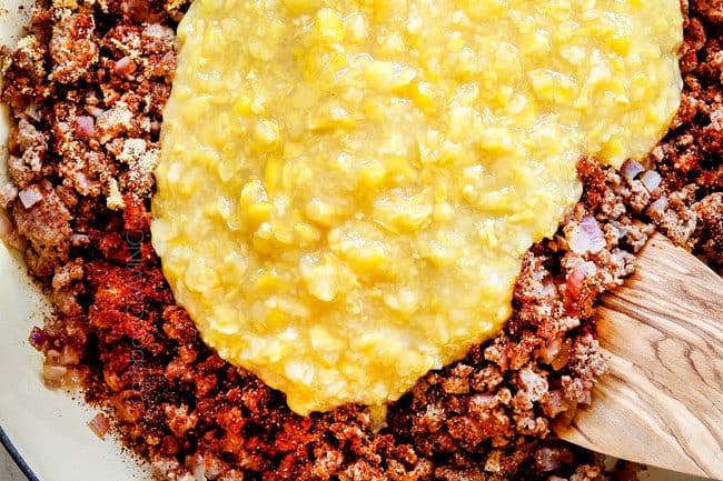 showing how to make buffalo mac and cheese by adding creamed corn to beef