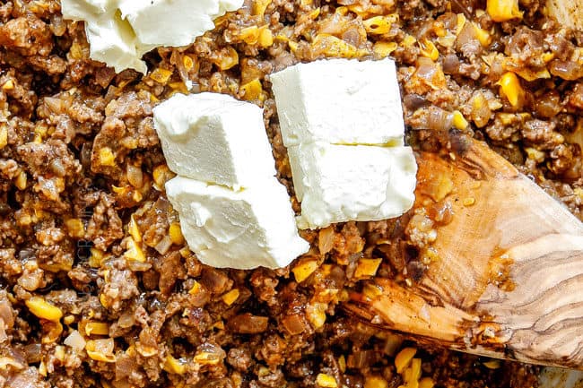 showing how to make buffalo mac and cheese by stirring cream cheese into sauce