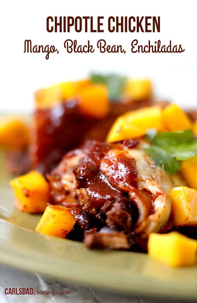 Chipotle Chicken Enchiladas with mango garnish on a green plate.