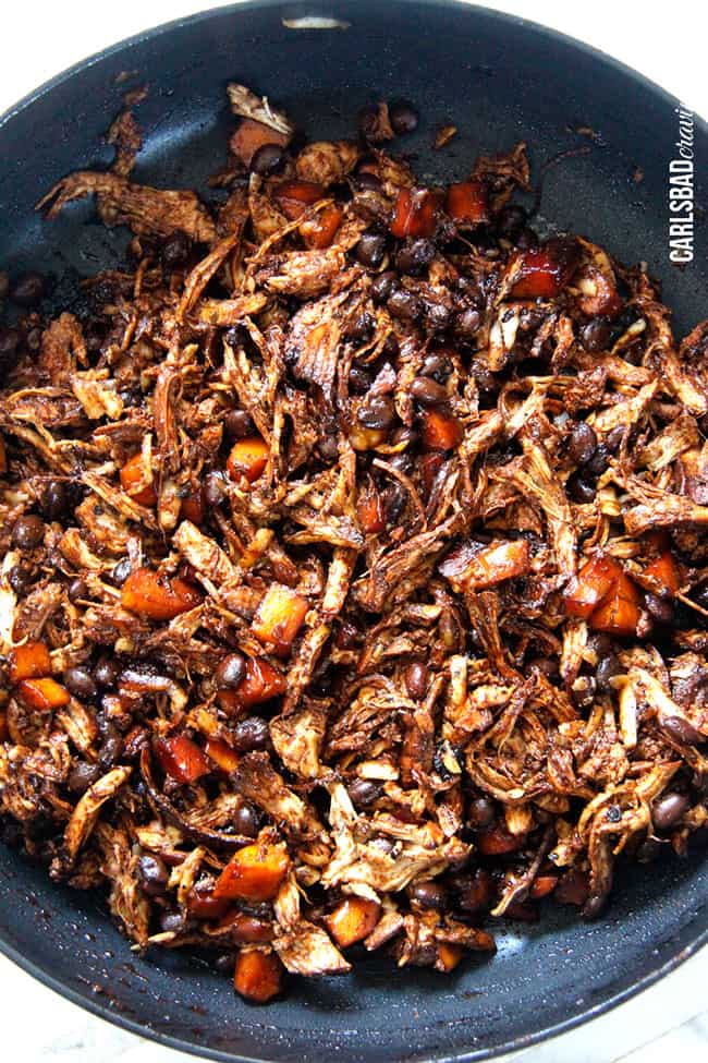 Showing how to make Chipotle Chicken Enchiladas by precooking the meat beans in a pan.
