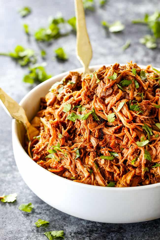 far away shot of Best Cafe Rio Sweet Pulled Pork in a white bowl with gold tongs