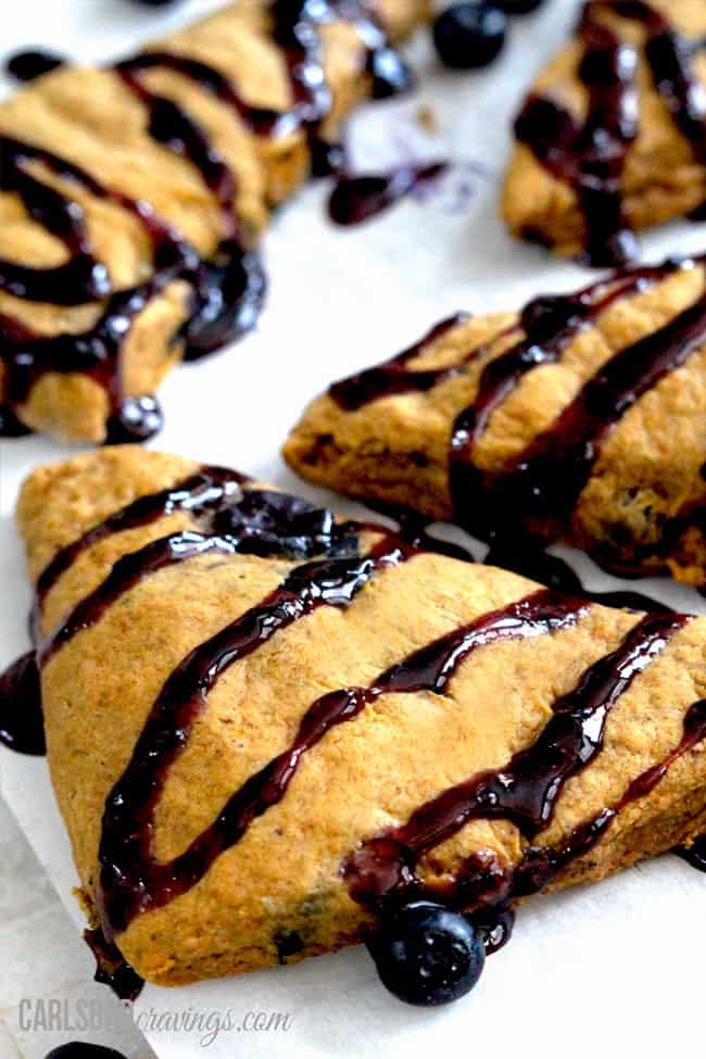 Pumpkin Scones with blueberry drizzle on top garnished with blueberries.