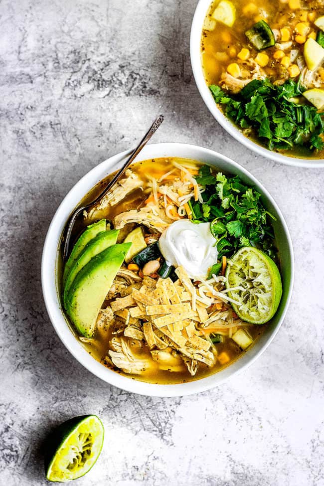 a bowl of healthy slow cooker chicken tortilla soup with homemade tortilla strips