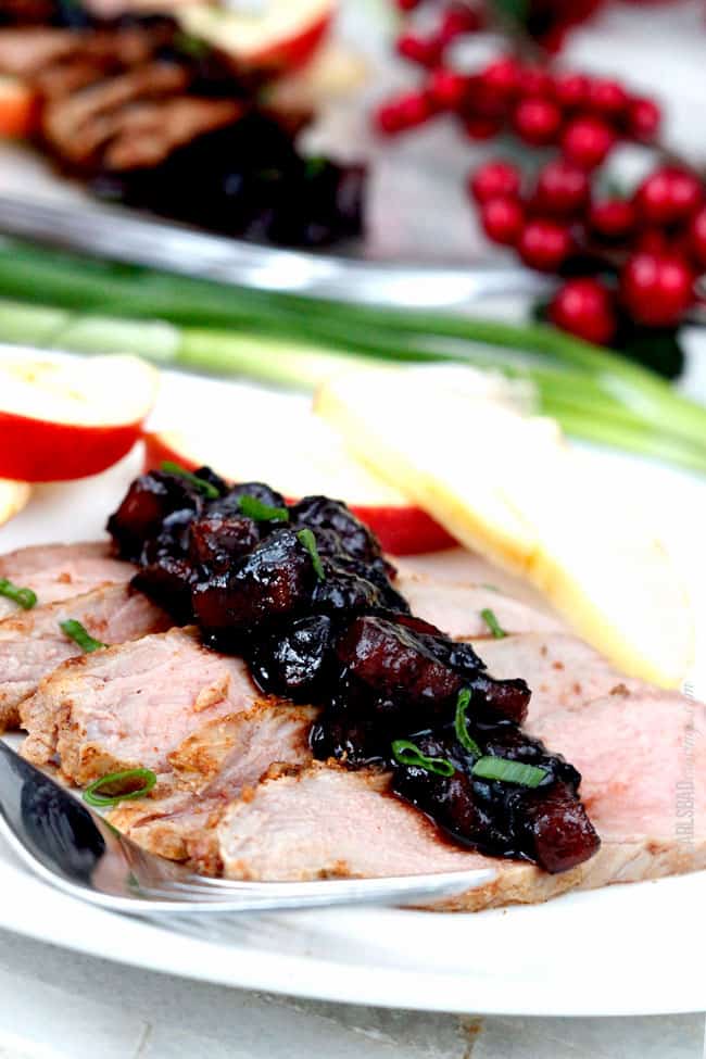 Cajun Pork Tenderloin sliced displayed on a white plate with apple garnish.