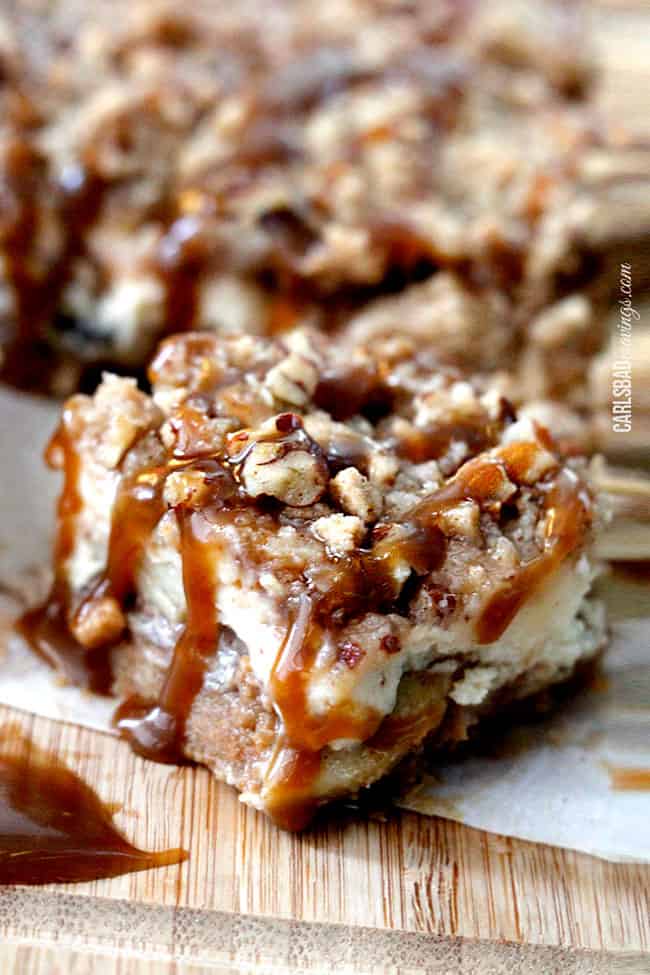 up close of a Caramel Apple Cheesecake Bar on a wooden cutting board.