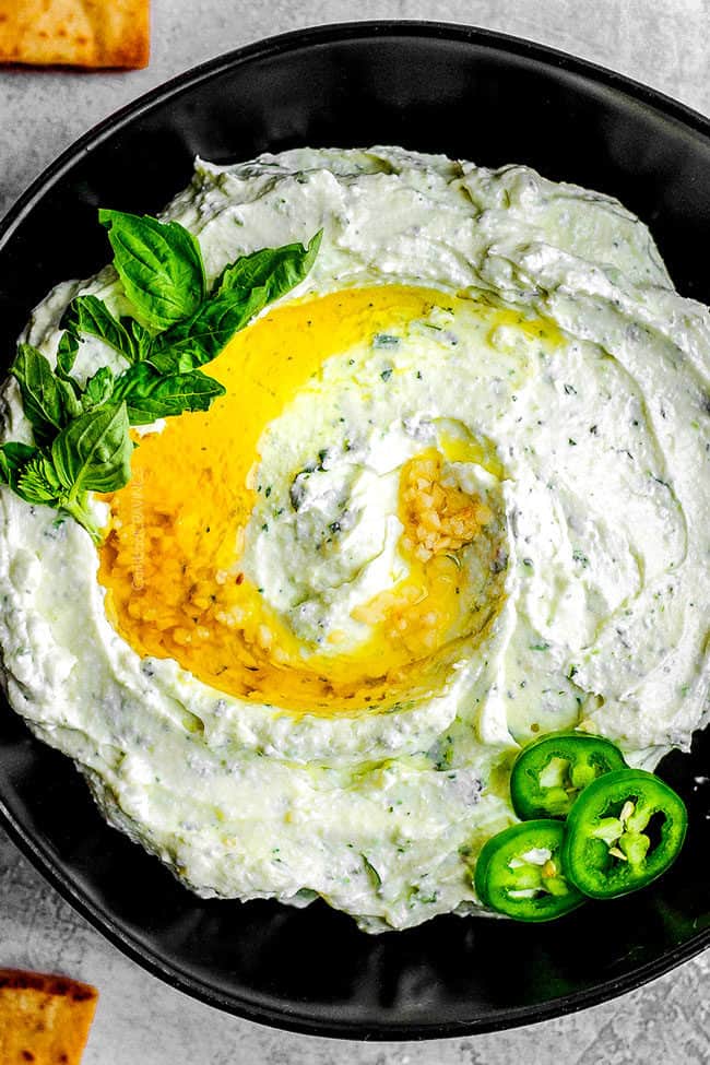 easy whipped feta dip in a black bowl drizzled with olive oil