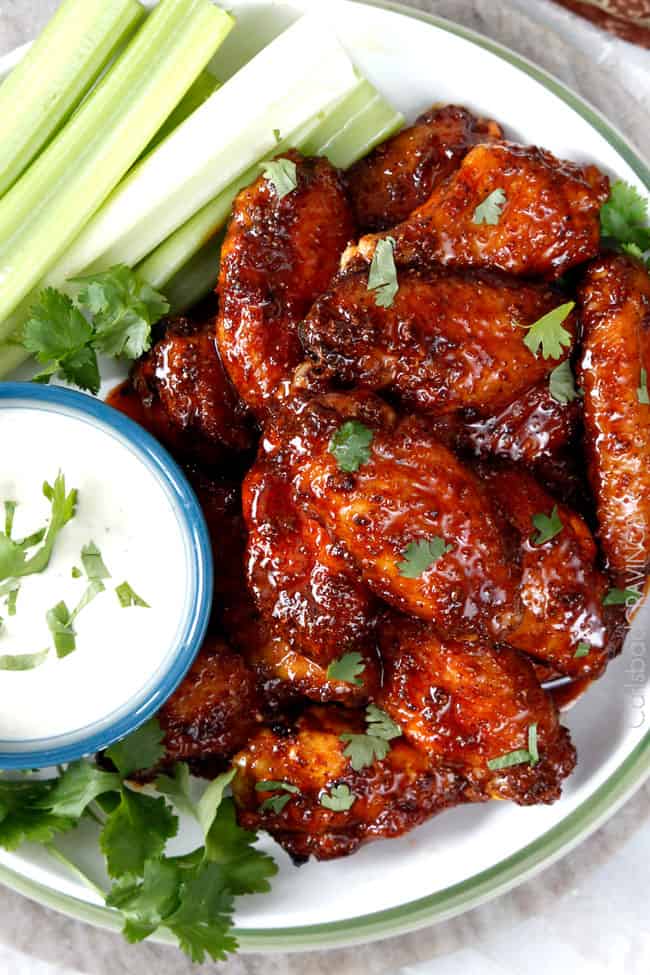 Top view of Honey Buffalo Hot Wings on a plate with celery and blue cheese dipping sauce.