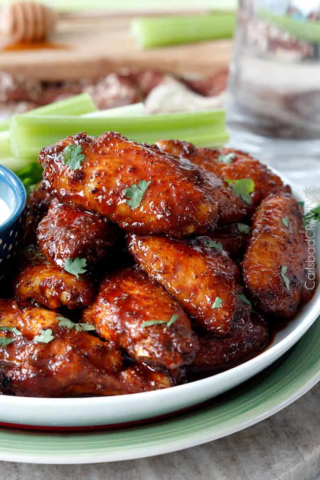 Honey Buffalo Hot Wings on a plate with celery dipping sauce, garnished with parsley.