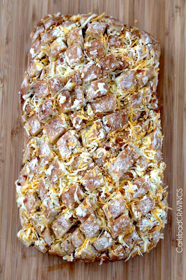 Showing how to make Bacon Ranch Pepper Jack Pull Apart Bread filling with cheese and spread.