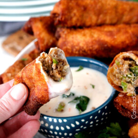 Philly Cheesesteak Egg Rolls dipped in alfredo sauce..