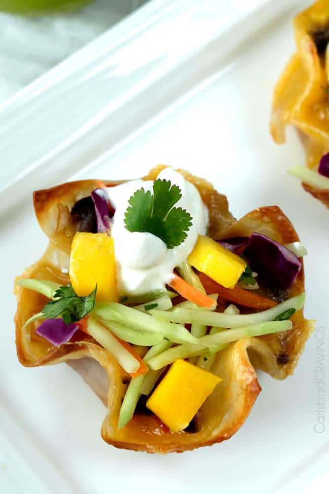 Top view of a Tuna Melt Cups garnished with mango, and herbs.