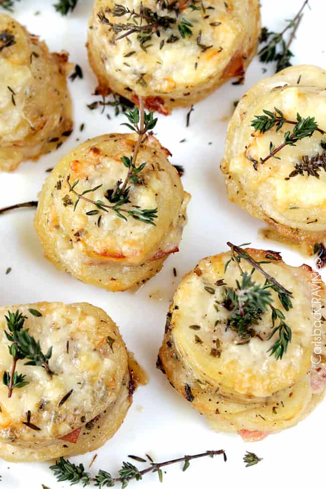 overhead view of cheesy potatoes and ham stacks topped with fresh thyme