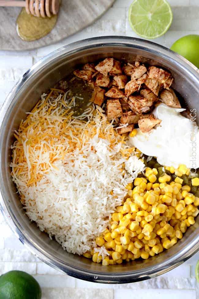 Showing how to make Salsa Verde Honey Lime Chicken by mixing cheese, corn, salsa verde, chicken in a bowl.