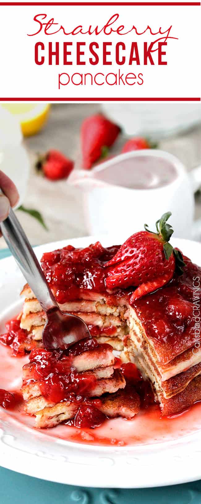 Strawberry Cheesecake Pancakes with a fork full of a large bite with strawberries and syrup.