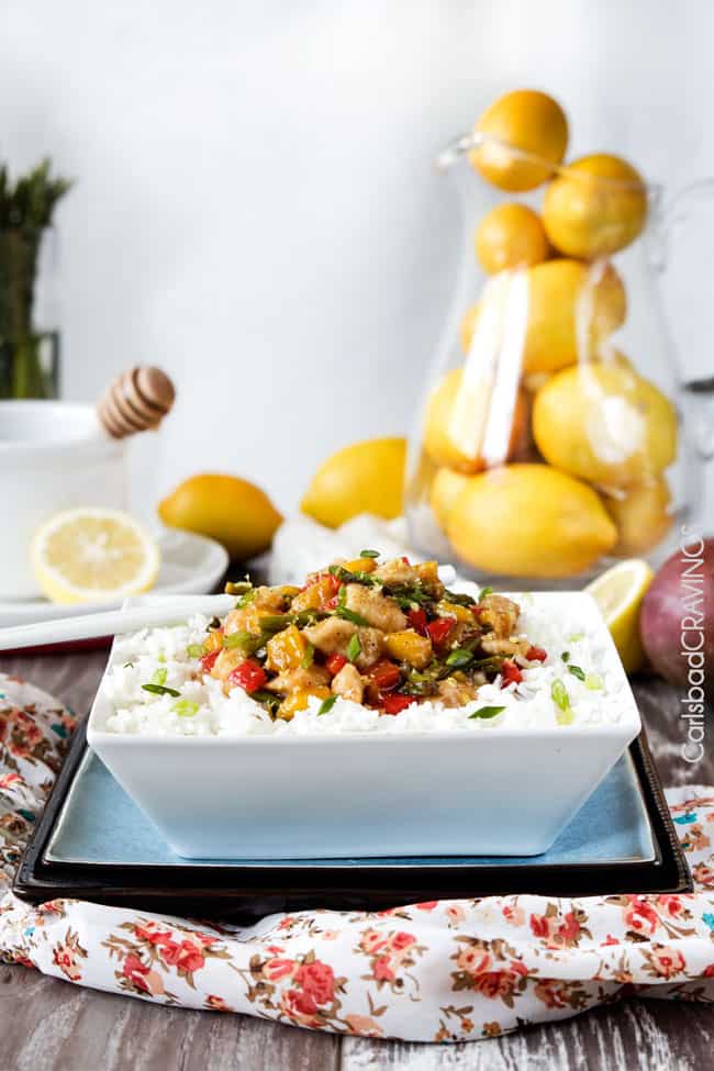 Side view of Honey Lemon Chicken Stir Fry over white rice in a bowl.