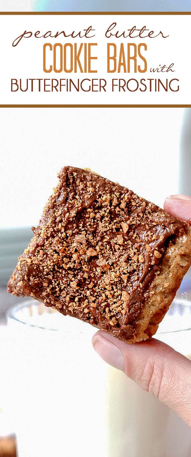 Single Peanut Butter Cookie Bars held up in a hand next to a cup of milk.