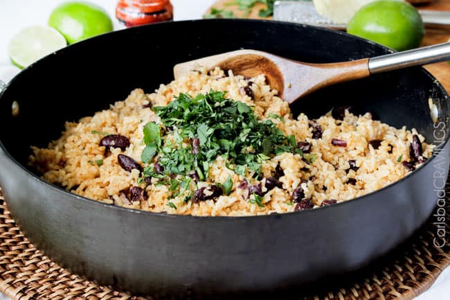 Showing how to make Red Beans and Rice by mixing rice and beans with cilantro.