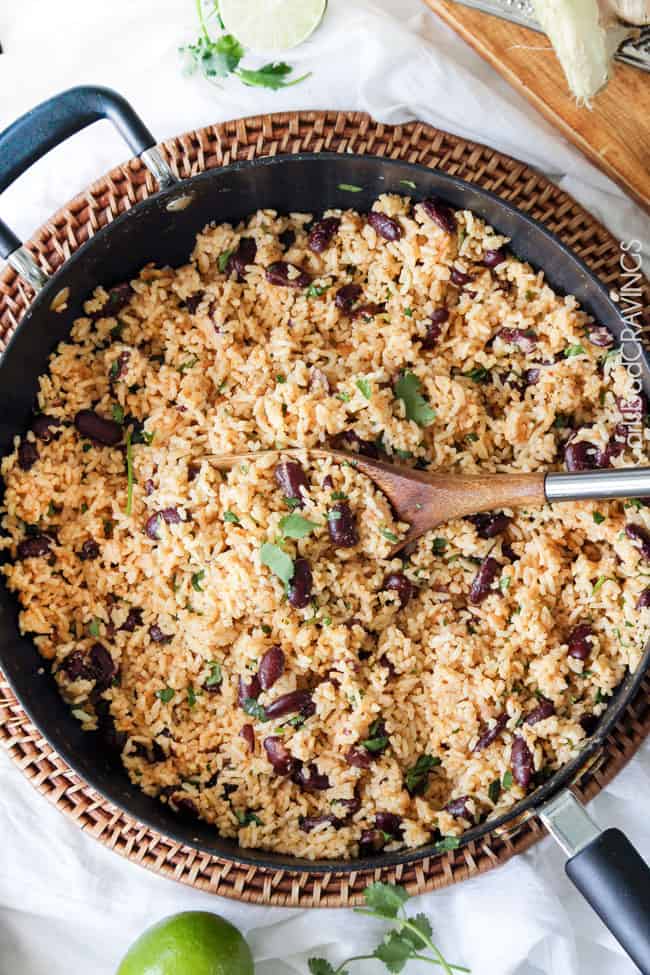 easy Red Beans and Rice in a black pan with a serving spoon in the rice.