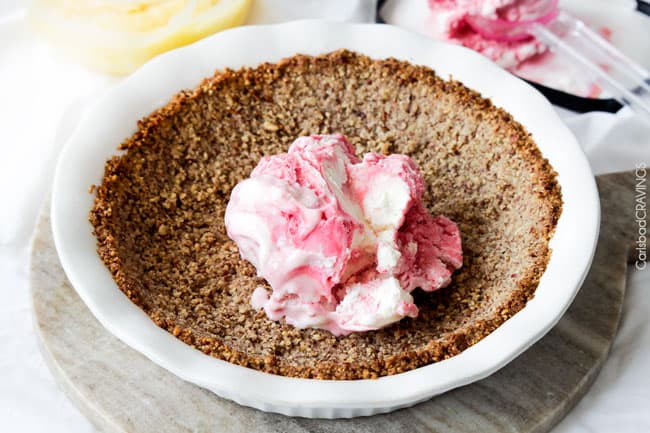 Showing how to make a Frozen Lemon Meringue Pie by adding ice cream in the pie pan with the crust.