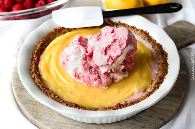 Showing how to make Frozen Lemon Meringue Pie by adding more ice cream as the third layer to the pie.