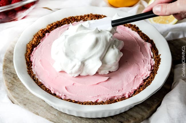 Showing how to make Frozen Lemon Meringue Pie by adding the white meringue on the top of the pink cake.