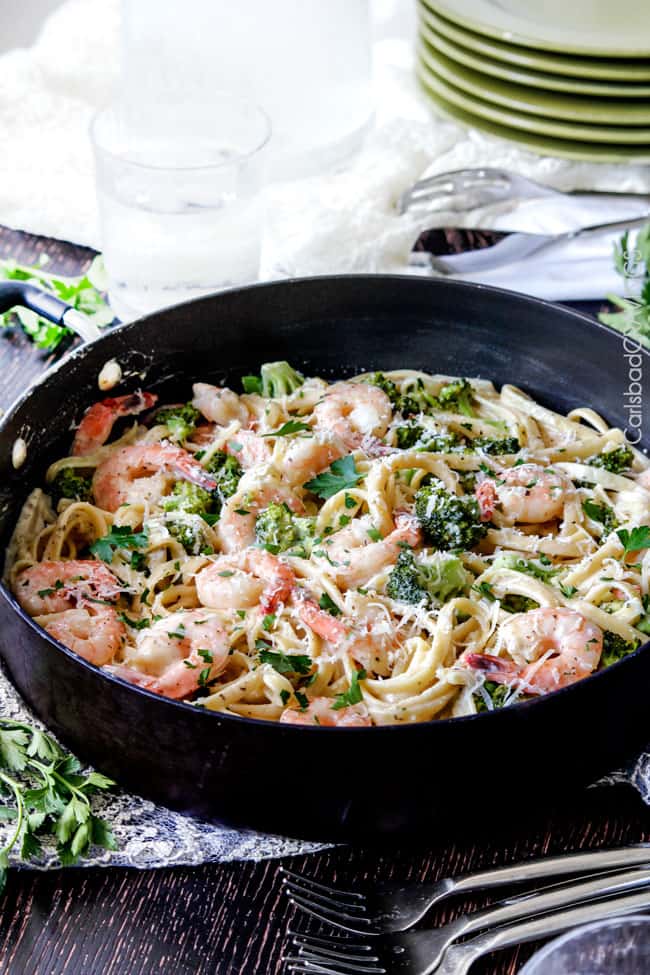 Shrimp Fettuccine Alfredo smothered in a velvety, creamy Alfredo sauce that's lightened up but tastes every bit as decadent as the finest restaurant Alfredo without any of the guilt or the price! This Roasted Shrimp Fettuccine Alfredo Recipe is bursting with juicy oven roasted shrimp. far away view of a skillet of Shrimp Alfredo