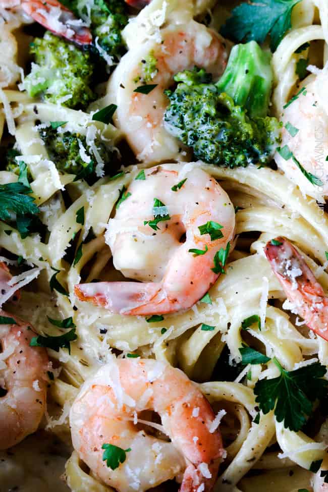 Shrimp Fettuccine Alfredo smothered in a velvety, creamy Alfredo sauce that's lightened up but tastes every bit as decadent as the finest restaurant Alfredo without any of the guilt or the price! This Roasted Shrimp Fettuccine Alfredo Recipe is bursting with juicy oven roasted shrimp. up close of healthy Shrimp Alfredo Recipe with broccoli