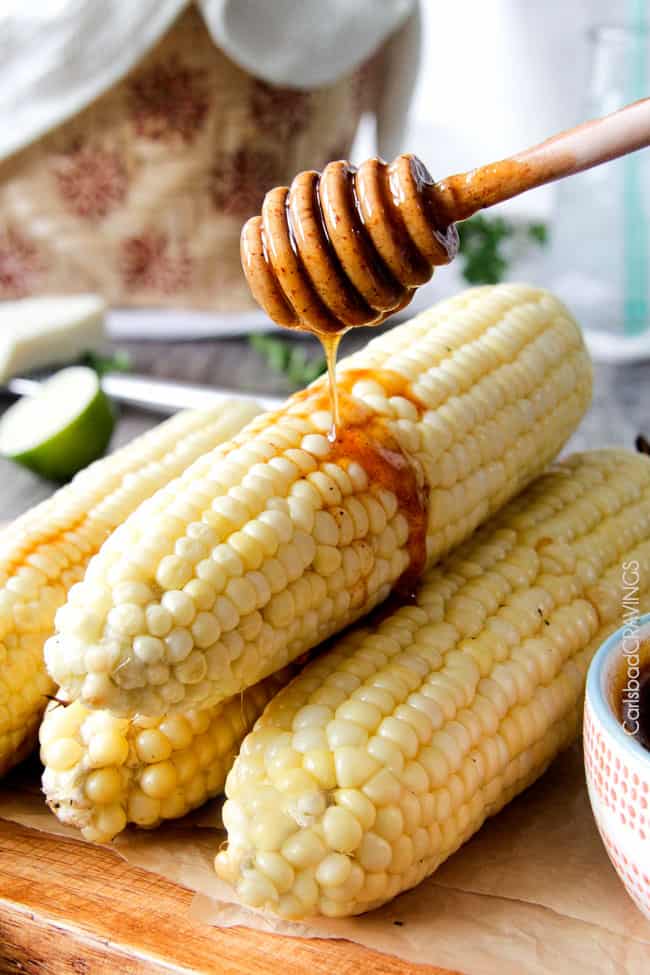 easy Roasted or grilled corn on the cob never tasted so delicious brushed with delectable Chipotle Honey Lime Butter sprinkled with cilantro and cotija cheese! Perfect for the 4th or roast year round. #corn #Mexicancorn #grilledcorn #chipotle