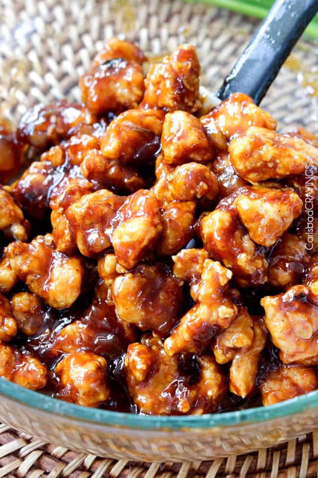 showing how to make Baked Chinese Pineapple Chicken by mixing it in a glass bowl with the sauce