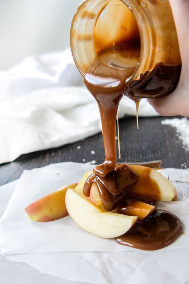 Pouring Coconut Caramel Sauce over top red apples.