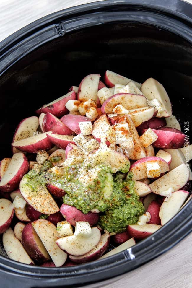 Mega creamy, mega flavorful, mega easy make-ahead Slow Cooker Mashed Potatoes are about to become your favorite go-to mashed potatoes. You will never need to peel or boil potatoes again! showing how to make crockpot mashed potatoes by adding potatoes, butter, garlic to slow cooker