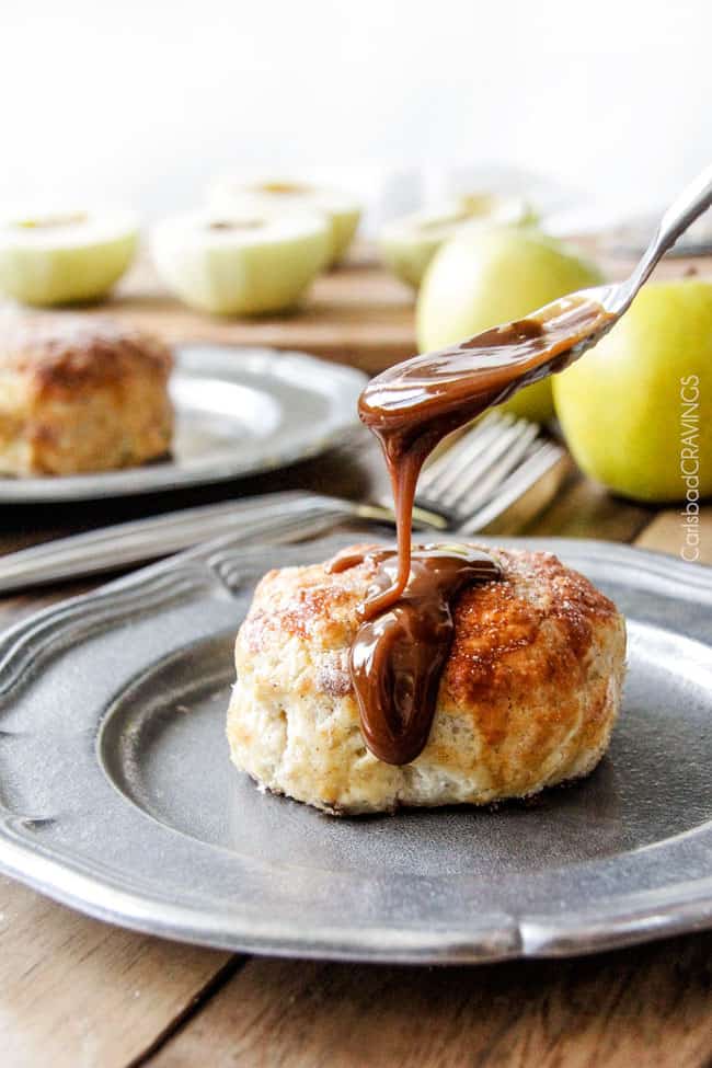 Caramel Apple Dumplings AKA the best apple dumplings ever! Perfectly buttery, flaky pastry, oozing cinnamon and sugar peanut butter filling all drizzled with silky caramel. showing how to make apple dumplings by covering with dumpling sauce