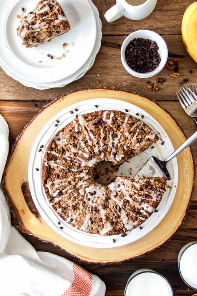 The best Banana ANYTHING ever! Moist Banana Coffee Cake riddled with chocolate chips and walnuts (optional) with an INCREDIBLY creamy cheesecake-like cream cheese filling all topped with brown sugar walnut streusel and vanilla drizzle.