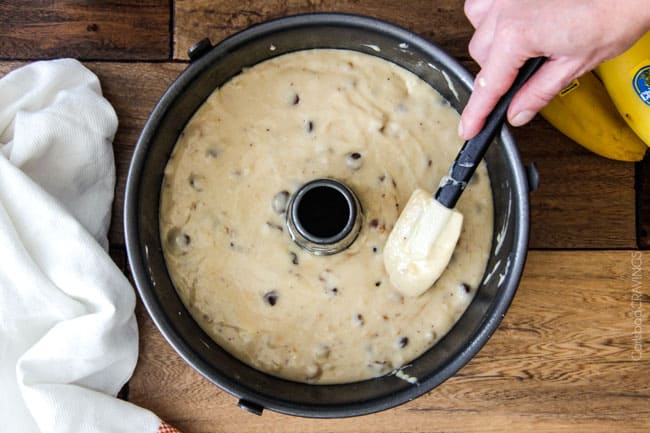 The best Banana ANYTHING ever! Moist Banana Coffee Cake riddled with chocolate chips and walnuts (optional) with an INCREDIBLY creamy cheesecake-like cream cheese filling all topped with brown sugar walnut streusel and vanilla drizzle. showing how to make easy coffee cake by topping cream cheese layer with more batter