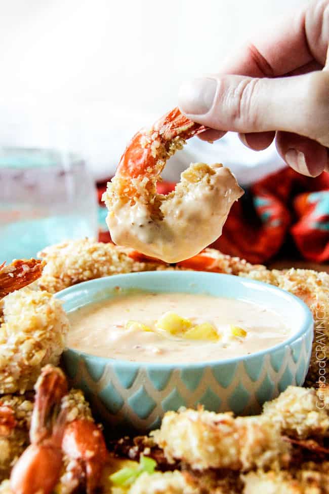 Side view of jumbo Coconut Shrimp being dipped.