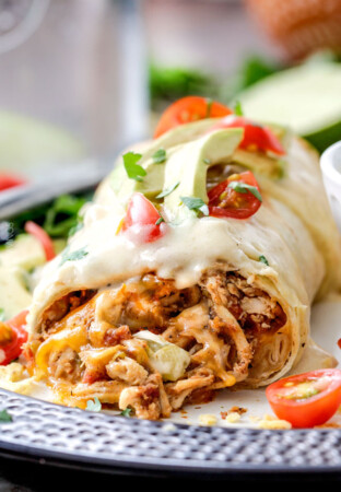 Easy Slow Cooker Shredded Mexican Chicken simmered with Mexican spices, salsa and green chilies for the BEST Mexican chicken perfect for tacos, burritos, tostadas, salads, etc. Couldn’t be any easier!