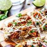 CPK inspired 20 Minute Thai Chicken Flatbread Pizza smothered in easy tangy peanut sauce, tender chicken, mozzarella cheese, crunchy carrots, sprouts and peanuts and the option of creamy coconut yogurt drizzle - an amazing flavor bursting quick dinner at a fraction of the cost.